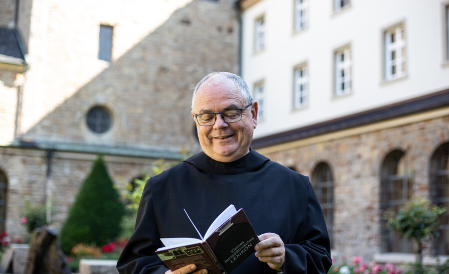 Br. Ansgar Stüfe blättert in seinem neuen Buch "Kleines benediktinisches Lexikon"